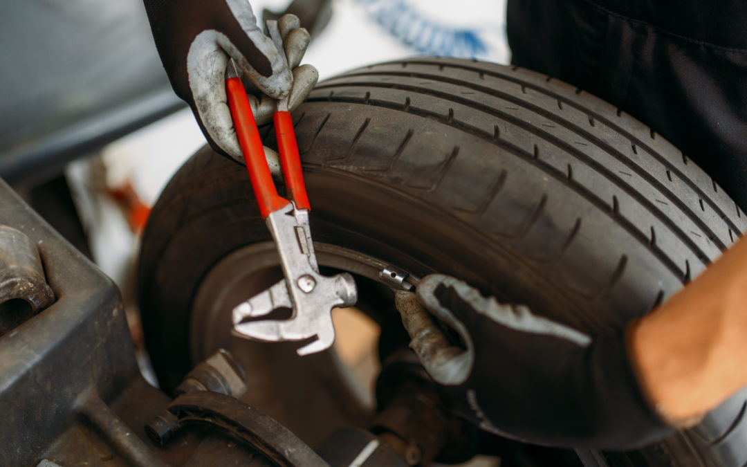 Auto mechanic balancing wheel, tire service